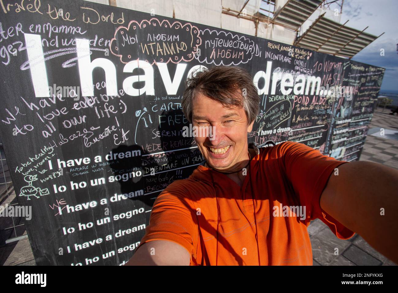 20-09-2015 Taormina, Italie. À Taormina, une terrasse d'observation - un homme dans un T-shirt orange, prend un selfie en particulier, en russe "nous aimons l'Italie" Banque D'Images