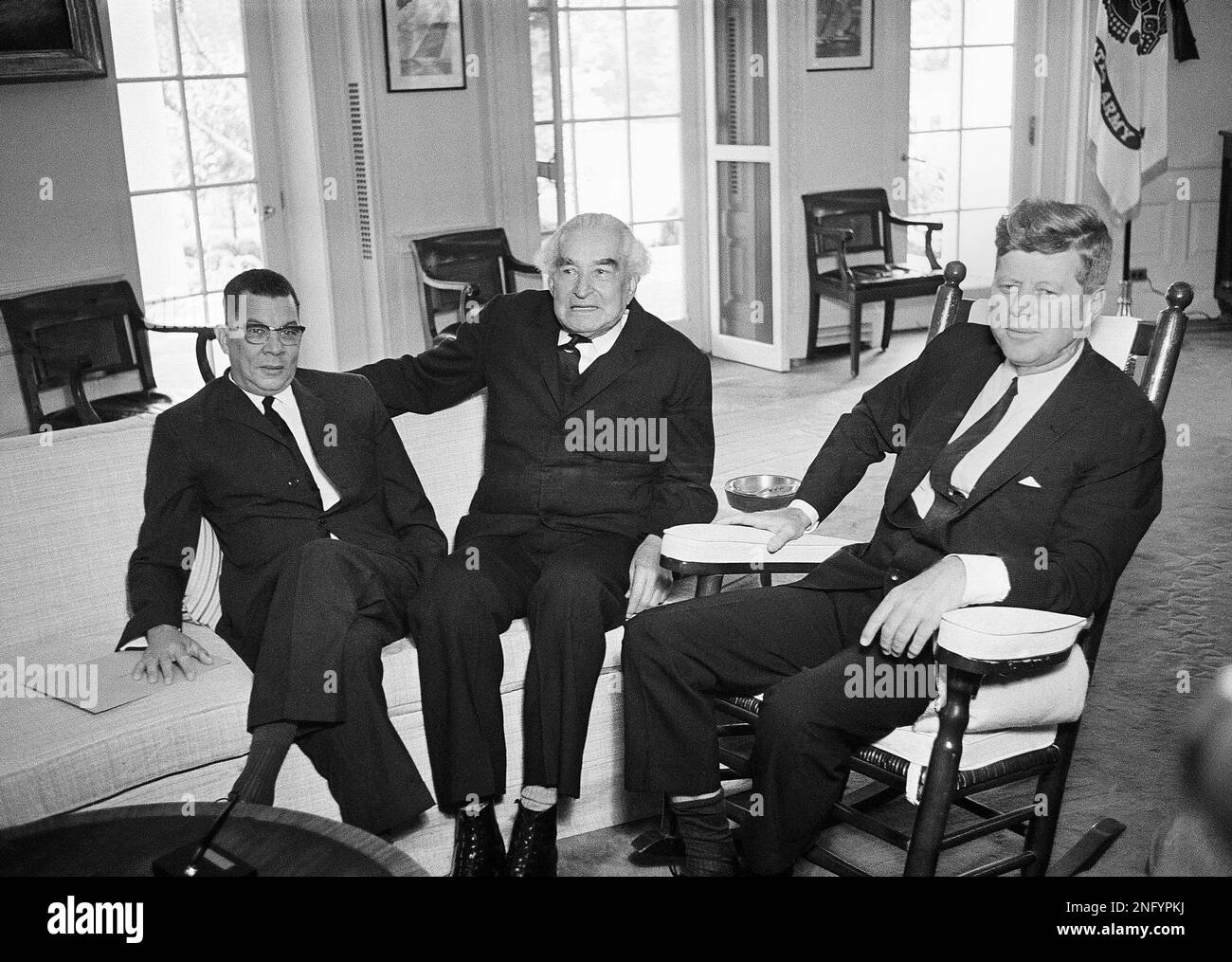 Sir Alexander Bustamante, prime minister of Jamaica, with white hair at center, poses with President John Kennedy at the White House before conferring in Washington on June 14, 1963. Sitting with Bustamenta, at left, is Donald Sangster, deputy prime minister of Jamaica. (AP Photo/Henry Griffin) Banque D'Images