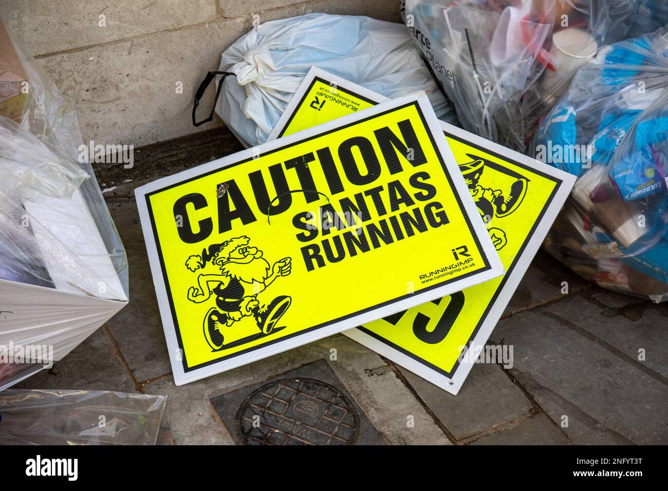 Attention. Santas en cours d'exécution. Jetez les panneaux d'avertissement de Santa Run dans une pile de déchets à Londres, en Angleterre. Banque D'Images
