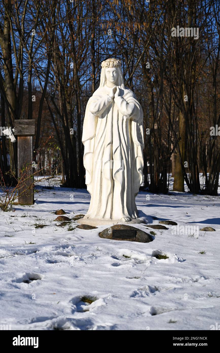 Lublin, Pologne. 08 février 2023. Figure blanche de la Vierge Marie dans la neige à l'extérieur de la vieille église en hiver. Banque D'Images