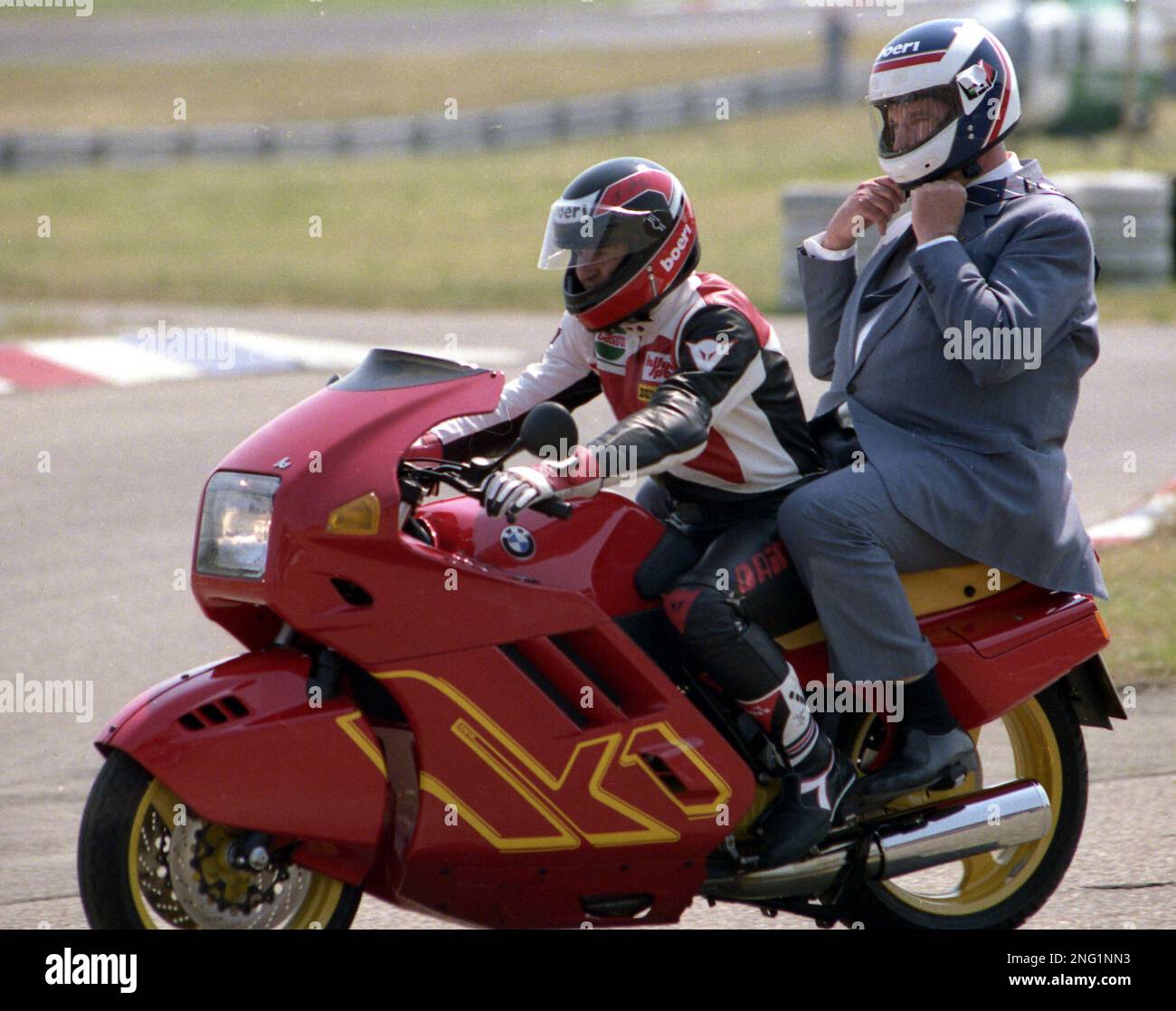 West German Chancellor Helmut Kohl, gets ready as pillion rider with former motorcycle racing rider Toni Mang on a new BMW K1 for a round on the Hockenheimring race circuit in Hockenheim, West Germany, May 28, 1989. Earlier Kohl had given the start signal for the 80 cc motorcycle race for the grand prize of Germany. (AP Photo/Arne Dedert) Banque D'Images