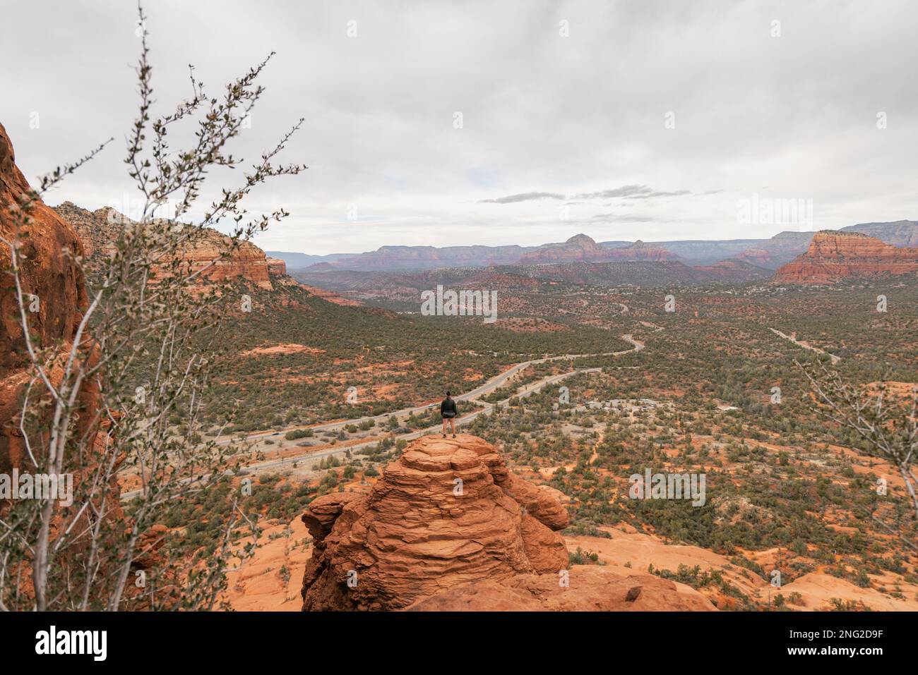 Femme randonneur se tenant sur Bell Rock avec des vues incroyables dans la forêt nationale de coconino à Sedona Arizona USA sur fond de nuages blancs. Banque D'Images