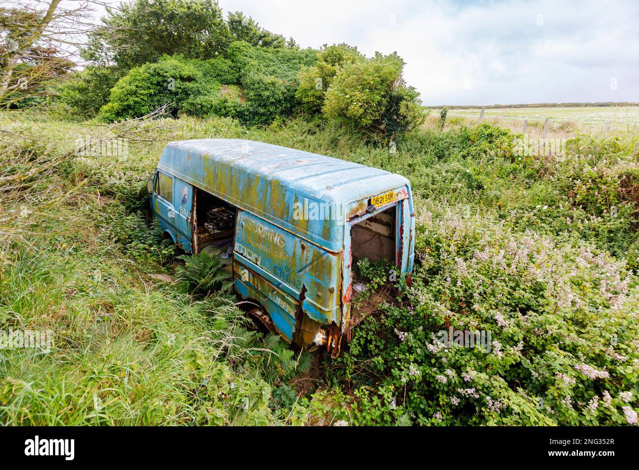 Un minibus bleu abandonné rouillé a été jeté à Marloes, un petit village de la péninsule de Marloes, dans le parc national de la côte de Pembrokeshire, dans l'ouest du pays de Galles Banque D'Images