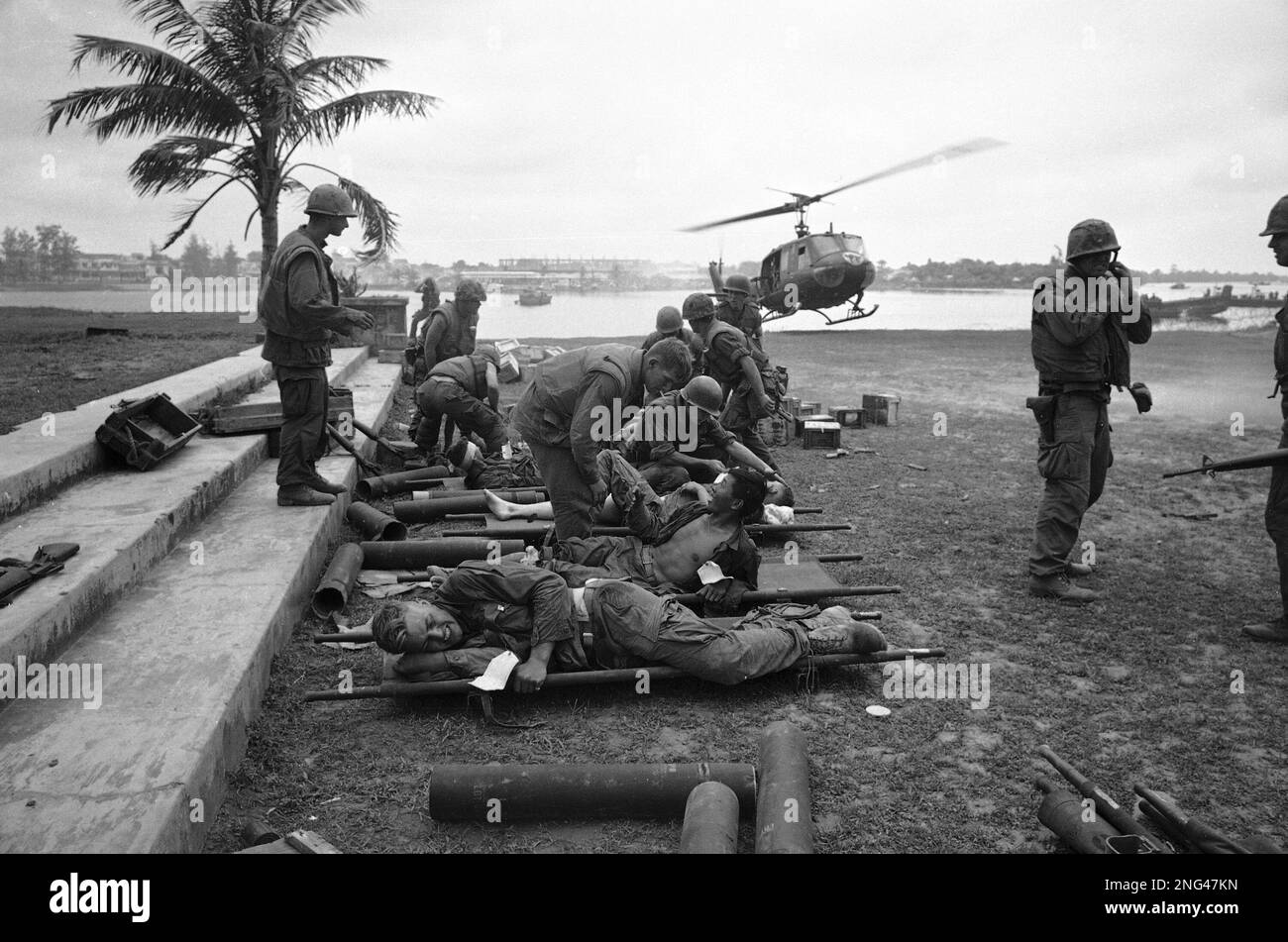 U.S. Marines wounded in the battle for the ancient Vietnamese imperial city of Hue lie on stretchers awaiting evacuation at a helicopter pickup point, Feb. 4, 1968. The city of Hue can be seen in the background beyond the Perfume River. (AP Photo) Banque D'Images