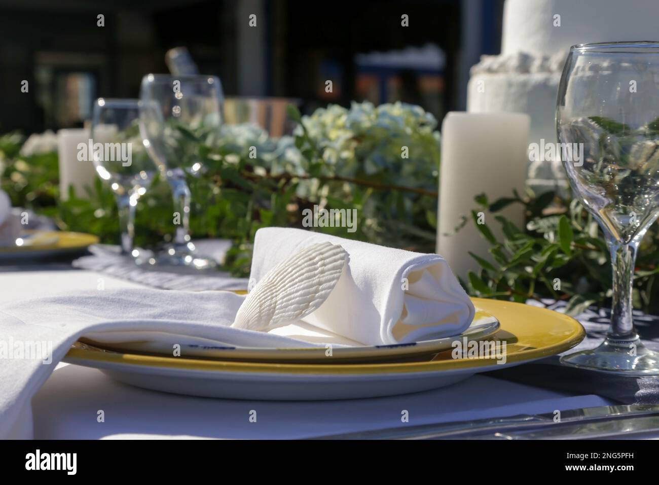 Décor élégant de table avec pièce maîtresse d'inspiration boho à feuilles vertes, coques et linge blanc en lin pour une soirée d'engagement, une réception de mariage ou Banque D'Images