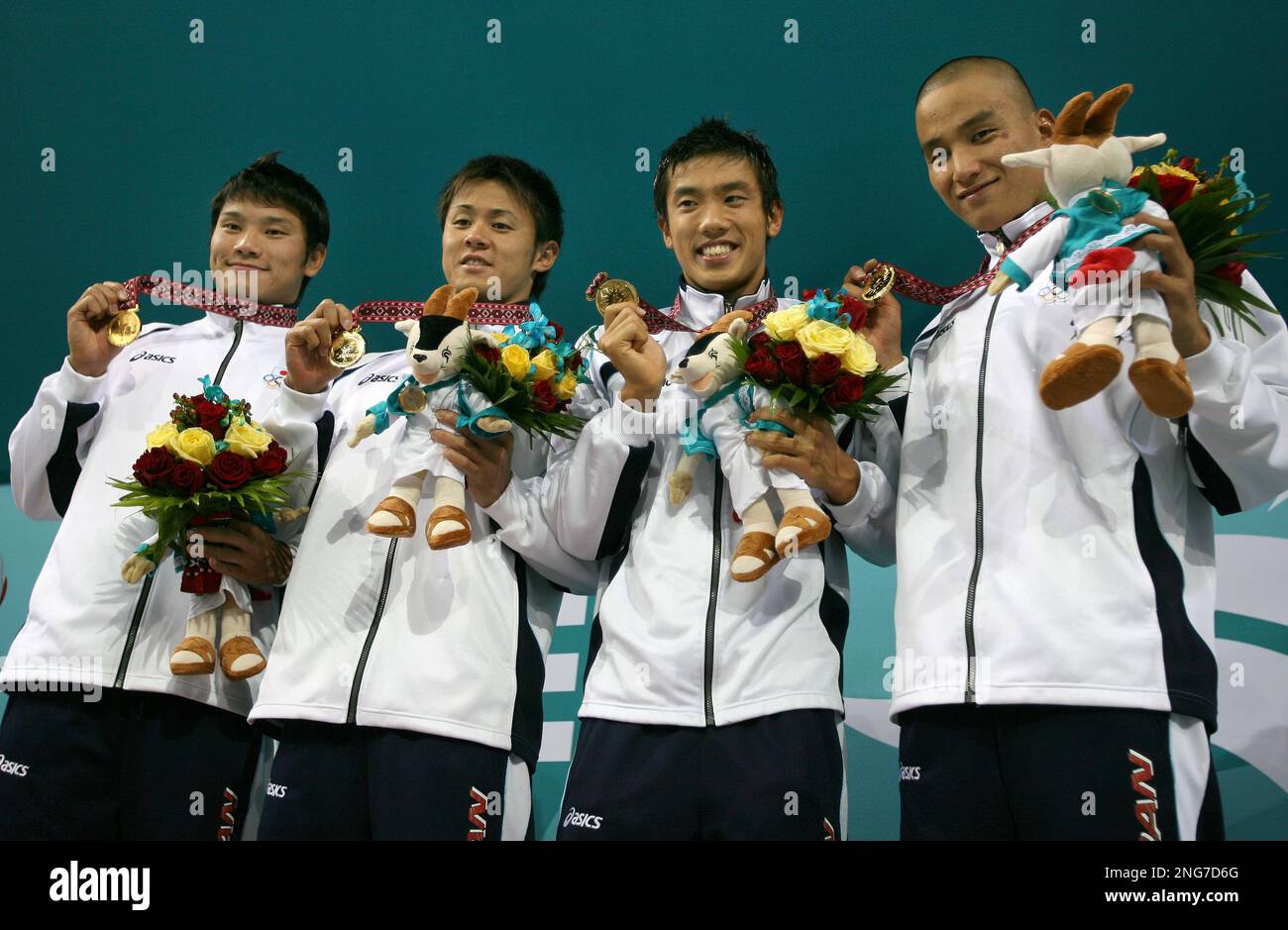 The Japanese team celebrate after receiving the gold medas they wonl in the final of the Men's 4x200m freestyle relay at the Asian Games in Doha, Qatar, Monday Dec. 4, 2006. (AP Photo/Junji Kurokawa) Banque D'Images