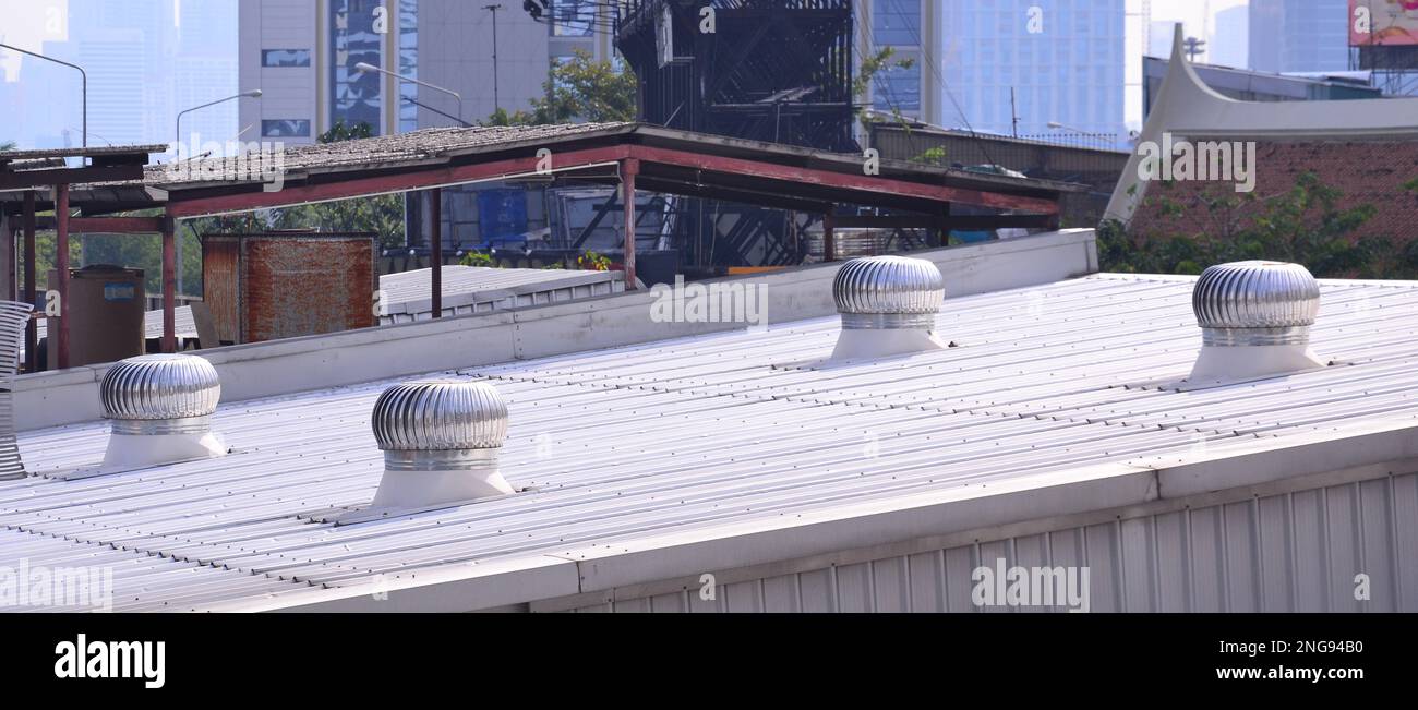 Ventilateurs d'évacuation montés sur le toit, conçus pour ventiler un bâtiment et le refroidir par temps chaud Banque D'Images