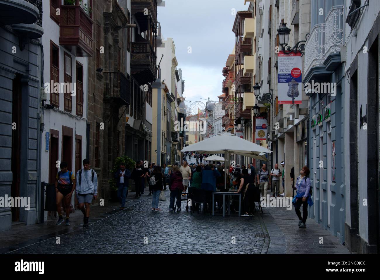 Rue piétonne à Santa Cruz de la Palma - les gens font du shopping et mangent à l'extérieur des tables de restaurant. Légère pluie d'où parasols. Banque D'Images