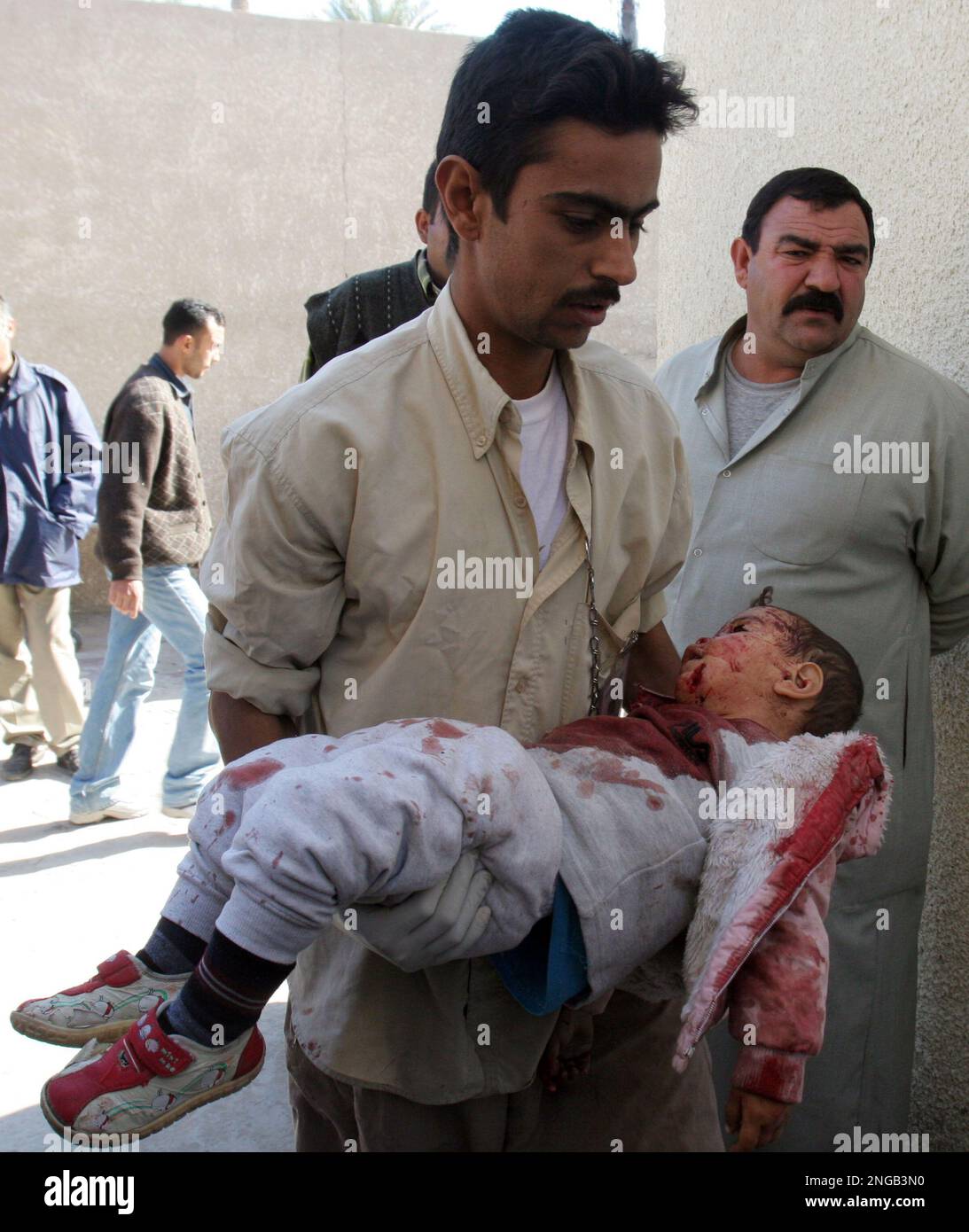 ** EDS NOTE GRAPHIC CONTENT ** A man carries the lifeless body of a child inside the morgue of Yarmouk hospital, in Bahdad, Iraq, Thursday, Nov. 24, 2005. A car bomb detonated outside Mahmoudiya hospital in the center of a town south of Baghdad Thursday, killing 30 and wounding 35, a doctor said. Among the dead were four police guards, three women and two children, said Dr. Dawoud al-Taie, the director of the Mahmoudiya hospital. (AP Phoot/Hadi Mizban) Banque D'Images