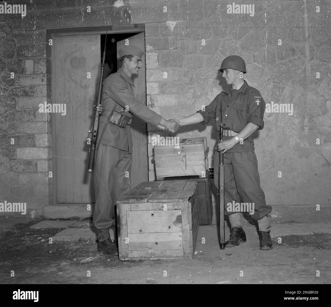 United Nations police force members, Pvt. Branco Milanovitz, left, of Yugoslavia, and Pvt. Fredericia Johansen of Denmark, shake hands in front of their barracks Nov. 17, 1956 near Ismailia, Egypt, near the Suez Canal. About 400 of the lightly armed troops are now on Egyptian territory. (AP Photo) Banque D'Images