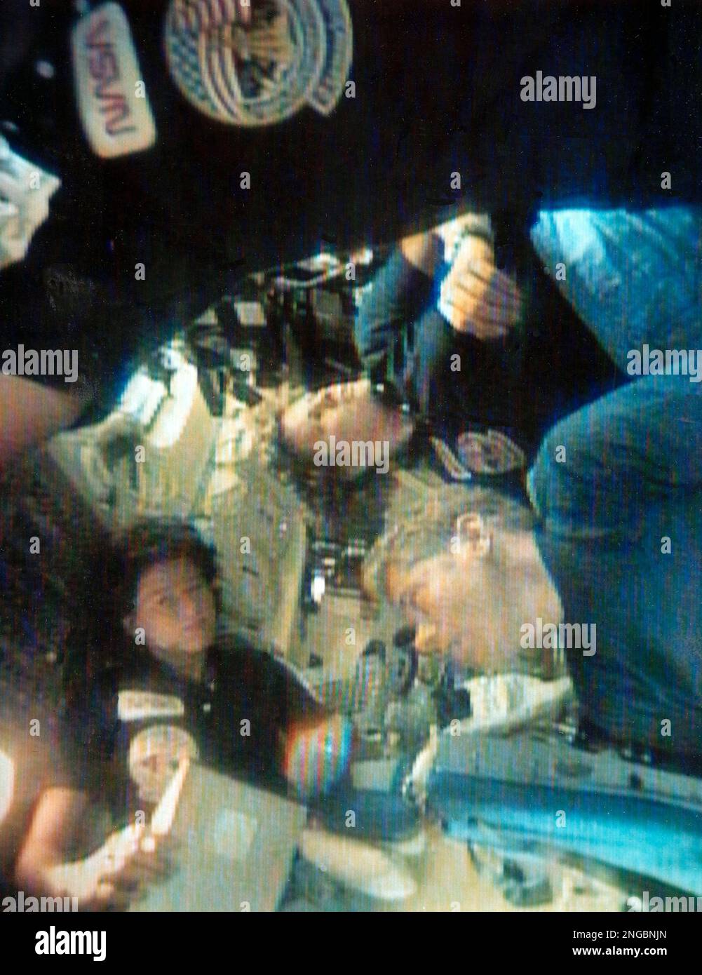 In this image provided by NASA, mission specialist Sally Ride, left, floats above the heads of David Leestma, center, and Kathryn Sullivan, Oct. 8, 1984, as she chats with them in the crowded quarters of the Shuttle Challenger. (AP Photo/NASA-TV) Banque D'Images