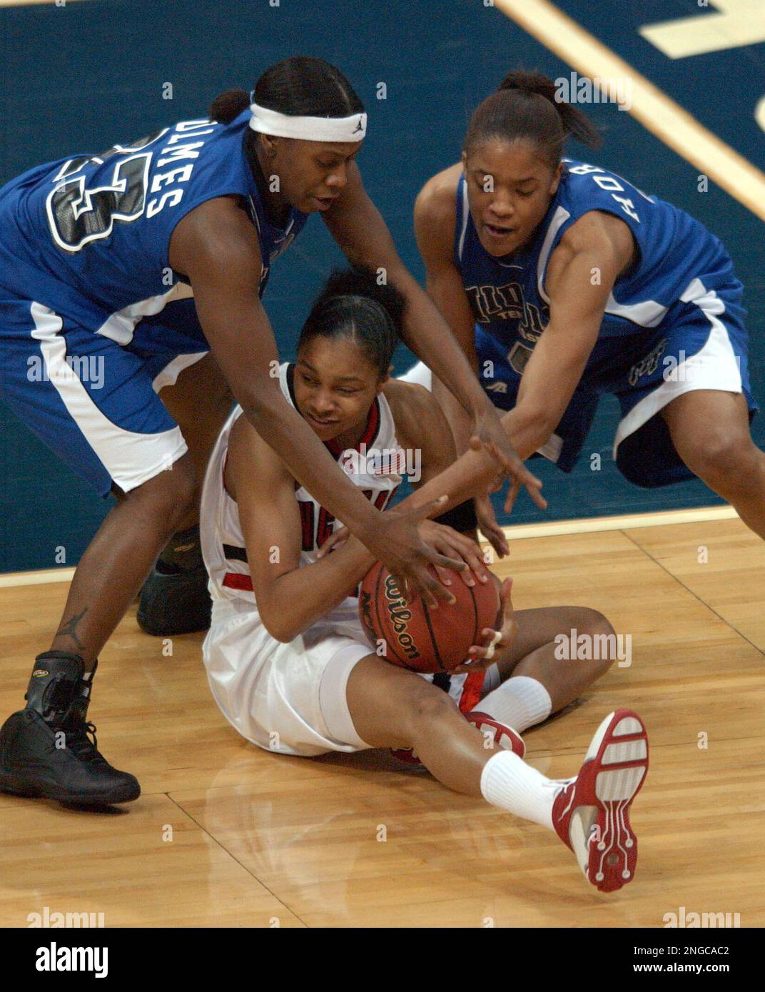 Middle Tennessee guard Patrice Holmes (23) and forward Krystle Horton (4) reach for the ball being held by North Carolina State forward Keisha Brown, center, during the first half of an NCAA tournament first-round game in Dallas, Saturday, March 19, 2005. (AP Photo/Tim Sharp) Banque D'Images