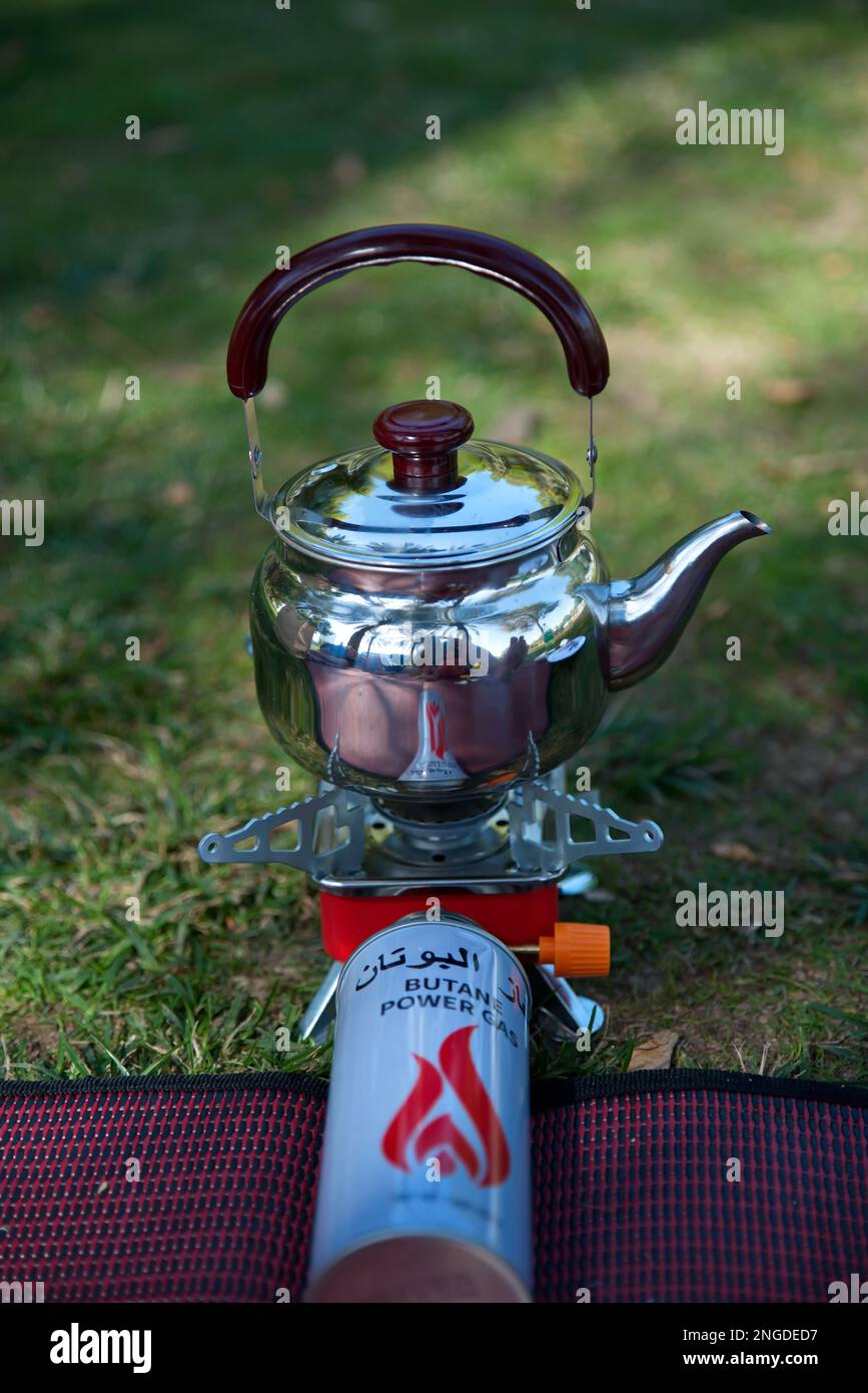 Faire le thé par bouilloire en camping extérieur poêle à gaz portable  (Traduction de l'arabe à l'anglais 'GAZ BUTANE' ce n'est pas le nom de  marque, le nom du contenu Photo Stock -