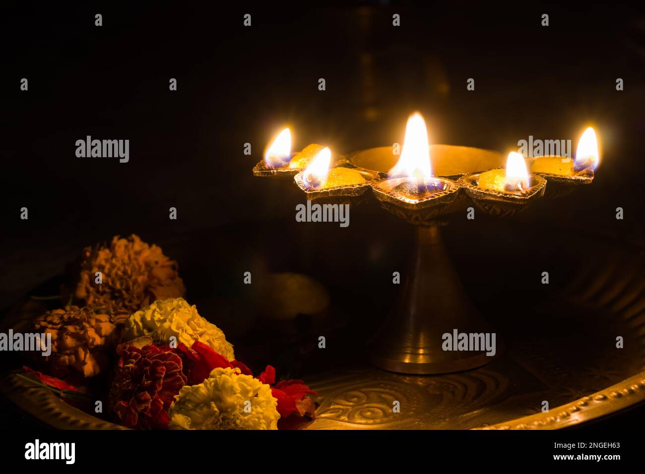 panch pradeep ou lampe à huile à cinq têtes qui brûlent avec une flamme brillante avec des fleurs marigold. ils sont utilisés dans les rituels hindous de puja comme durga , saraswati , Banque D'Images