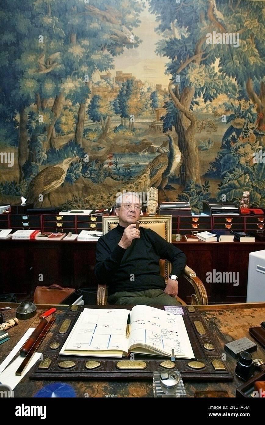 French lawyer Jacques Verges seen in this Feb. 24, 2004 file photo, smokes a cigar at his Paris office. Verges announced Saturday, March 27, 2004, he has been asked to defend former Iraqi leader Saddam Hussein. Verges has formerly defended Venezuelan terrorist Carlos the Jackal, confessed serial killer Charles Sobhraj and the Nazi Gestapo chief Klaus Barbie. (AP Photo/Laurent Rebours) Banque D'Images