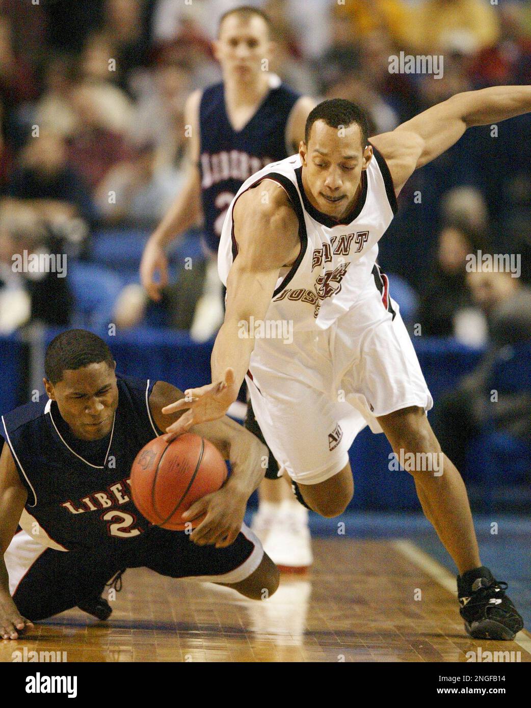 Liberty's Brian Woodson, left, and Saint Joseph's John Bryant battle for a loose ball during the first half of their NCAA men's basketball championship first round game Thursday, March 18, 2004, in Buffalo, N.Y. (AP Photo/Stephan Savoia) Banque D'Images
