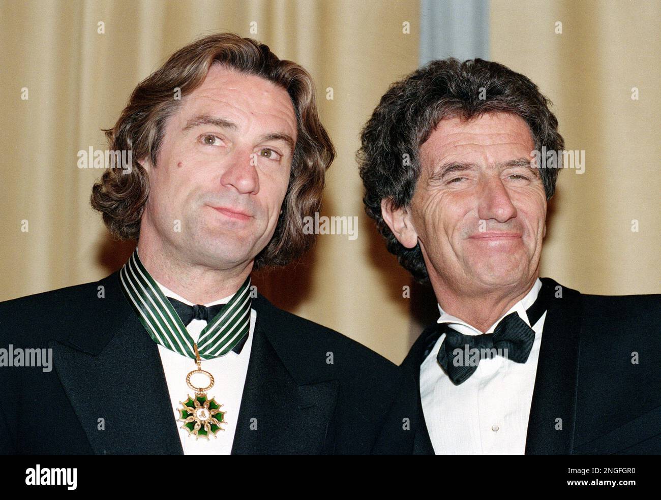 American actor Robert De Niro, left, receives the French Medal of Art and Letters from French Minister of Culture, Jack Lang, right, during the 44th Cannes Film Festival at the French Riviera, on May 17, 1991. (AP Photo/Jose Goitia) Banque D'Images