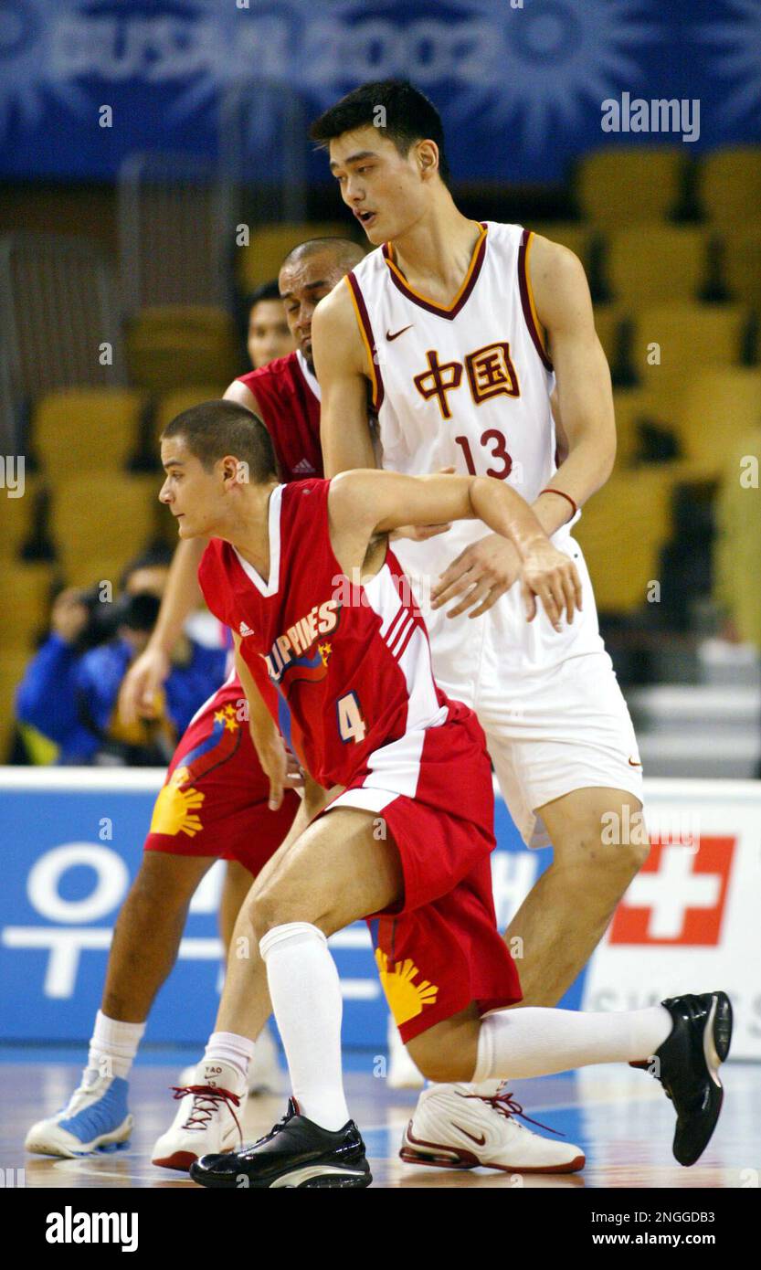 China's basketball star Yao Ming is double-teamed by the Philippines Noy Castillo (4) and Asi Taulava during their basketball game at Geumjeong Gymnasium in the 14th Asian Games at Busan, South Korea, Tuesday, Oct. 8, 2002. (AP Photo/Bullit Marquez) Banque D'Images