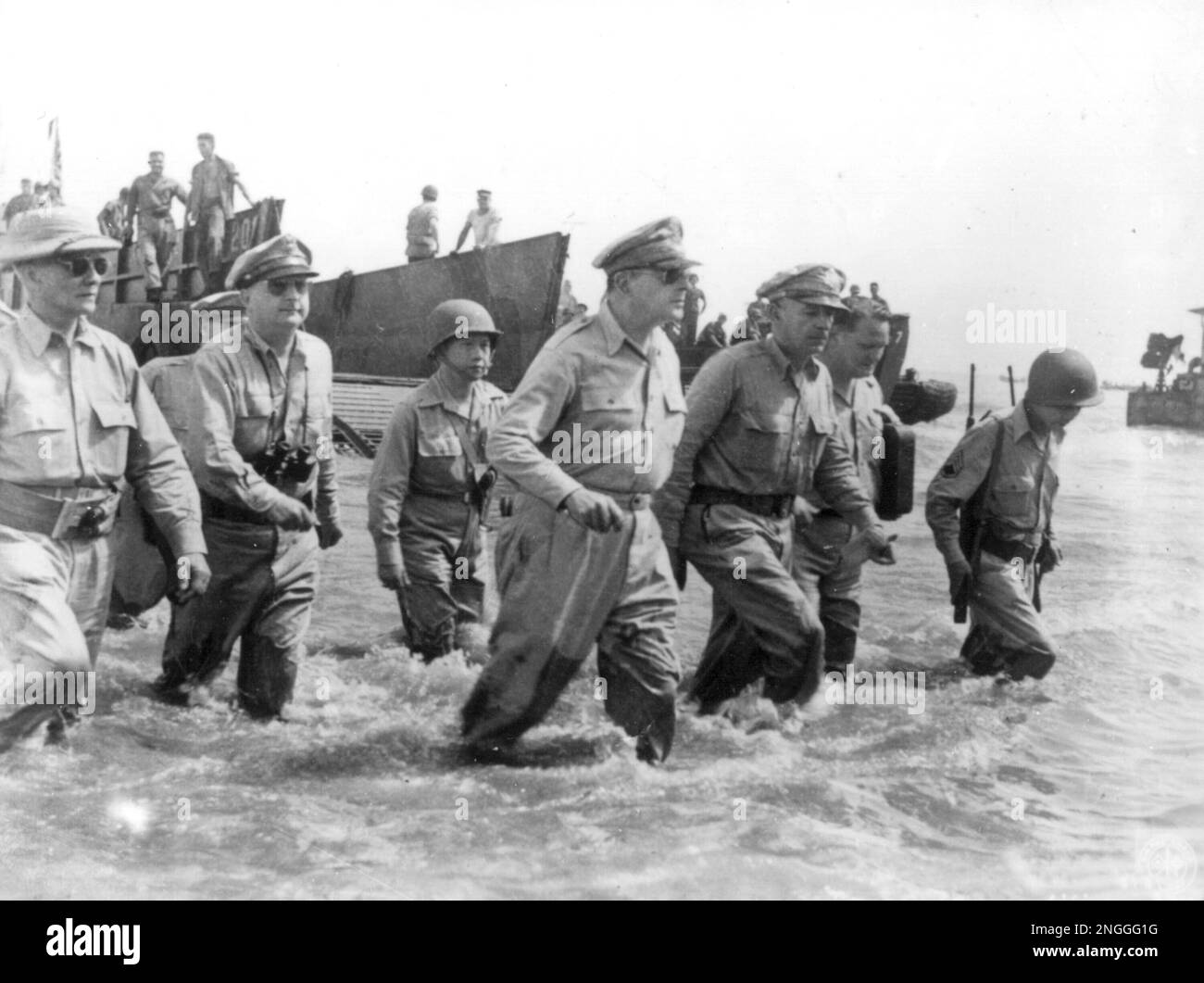 In this photo provided by the U.S. Army, Gen. Douglas MacArthur, center, is accompanied by his officers and Sergio Osmena, president of the Philippines in exile, extreme left, as he wades ashore during landing operations at Leyte, Philippines, October 20, 1944, after U.S. forces recaptured the beach of the Japanese-occupied island. To his left is Lt. Gen. Richard K. Sutherland, his chief of staff. (AP Photo/U.S. Army) Banque D'Images