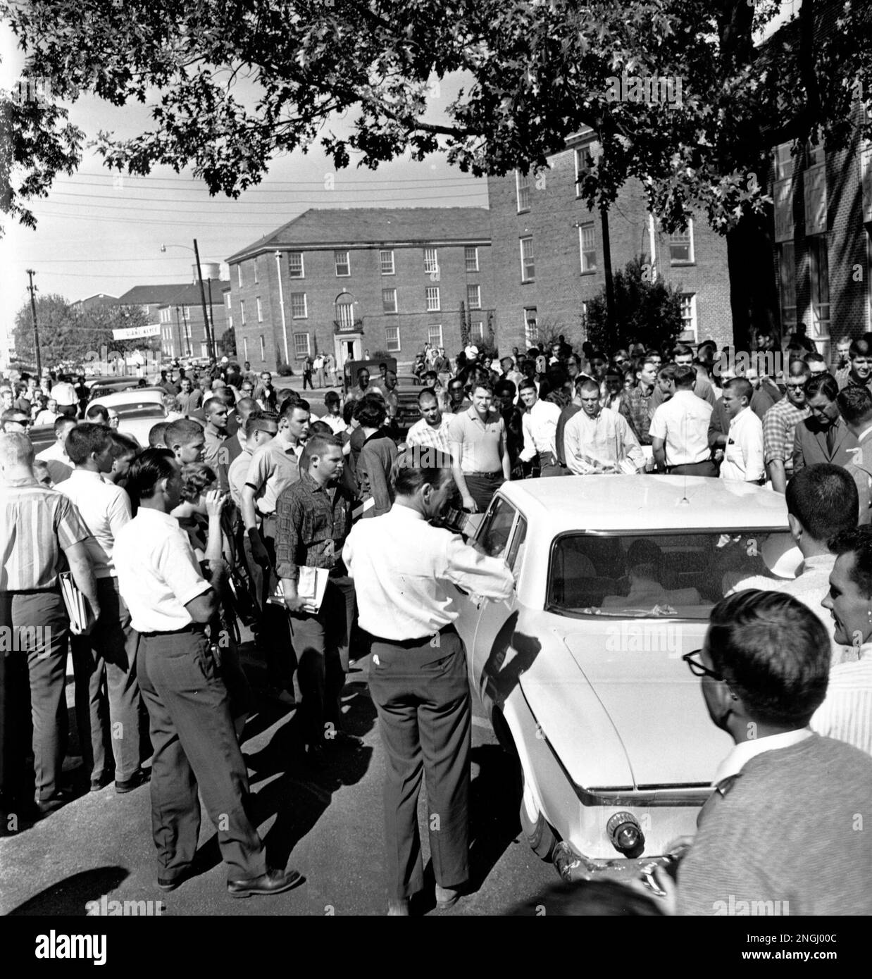 Students crowd the car carrying James Meredith, seated left rear, to the Ole Mississippi campus in Oxford, Miss. on Oct. 2, 1962. Meredith, a civil rights activist, is the first black person to attend the University of Mississippi after desegregation. Several students hurled jeers and taunts. (AP Photo) Banque D'Images
