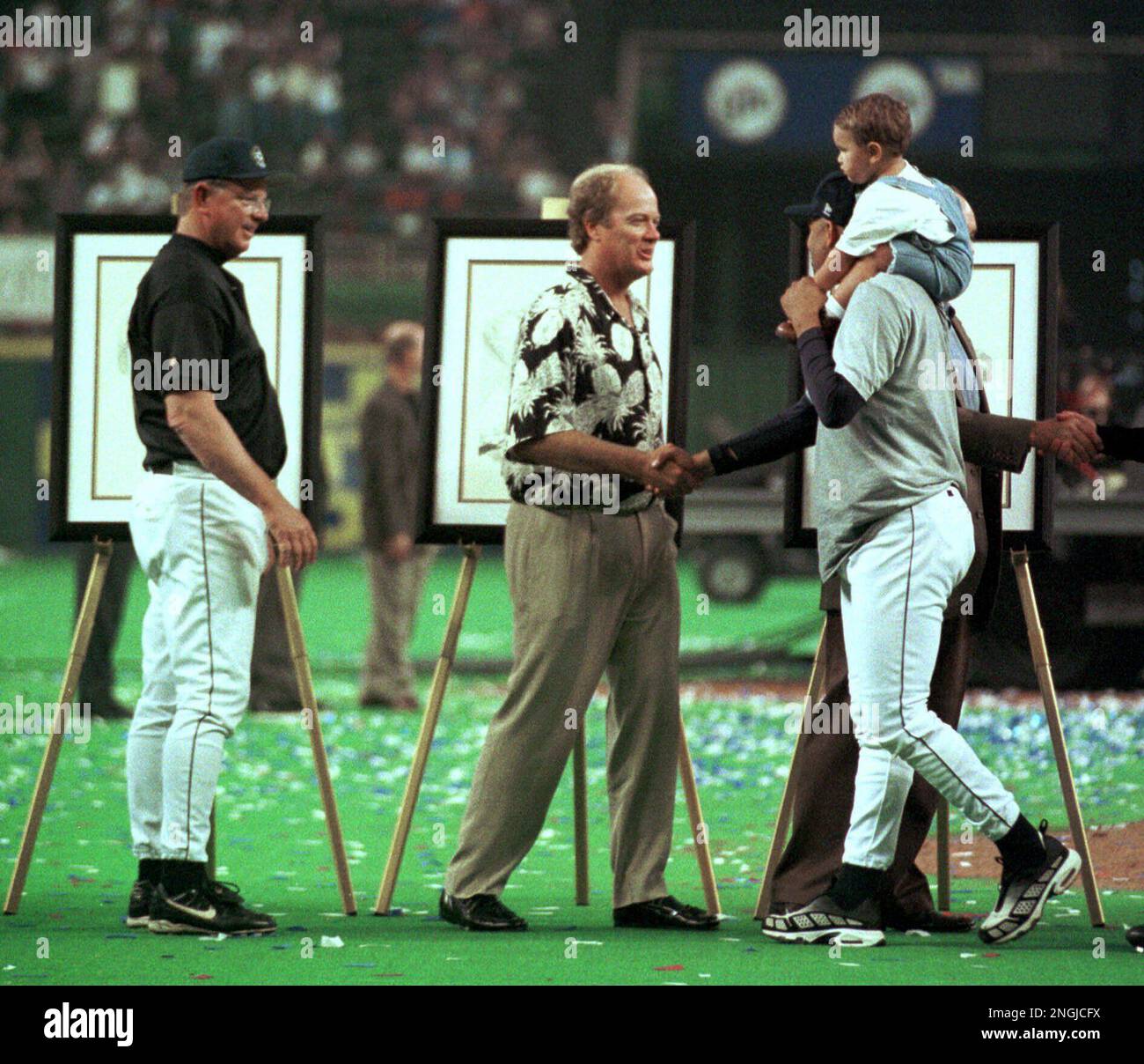 Houston Astros pitcher Jose Lima, right, carries his son, Jose Jr., on his shoulders as he shakes hands with former Astros pitcher Mike Scott and manager Larry Dierker looks on during closing ceremonies at the final regular-season game in the Astrodome Sunday, Oct. 3, 1999, in Houston. (AP Photo/Tim Johnson) Banque D'Images