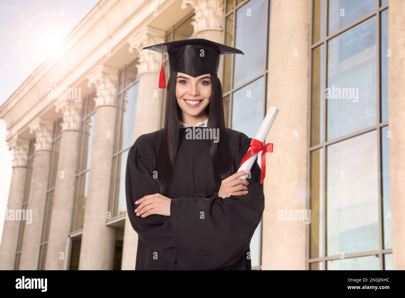 Joyeux étudiant avec un chapeau de diplôme et un diplôme en plein air Banque D'Images