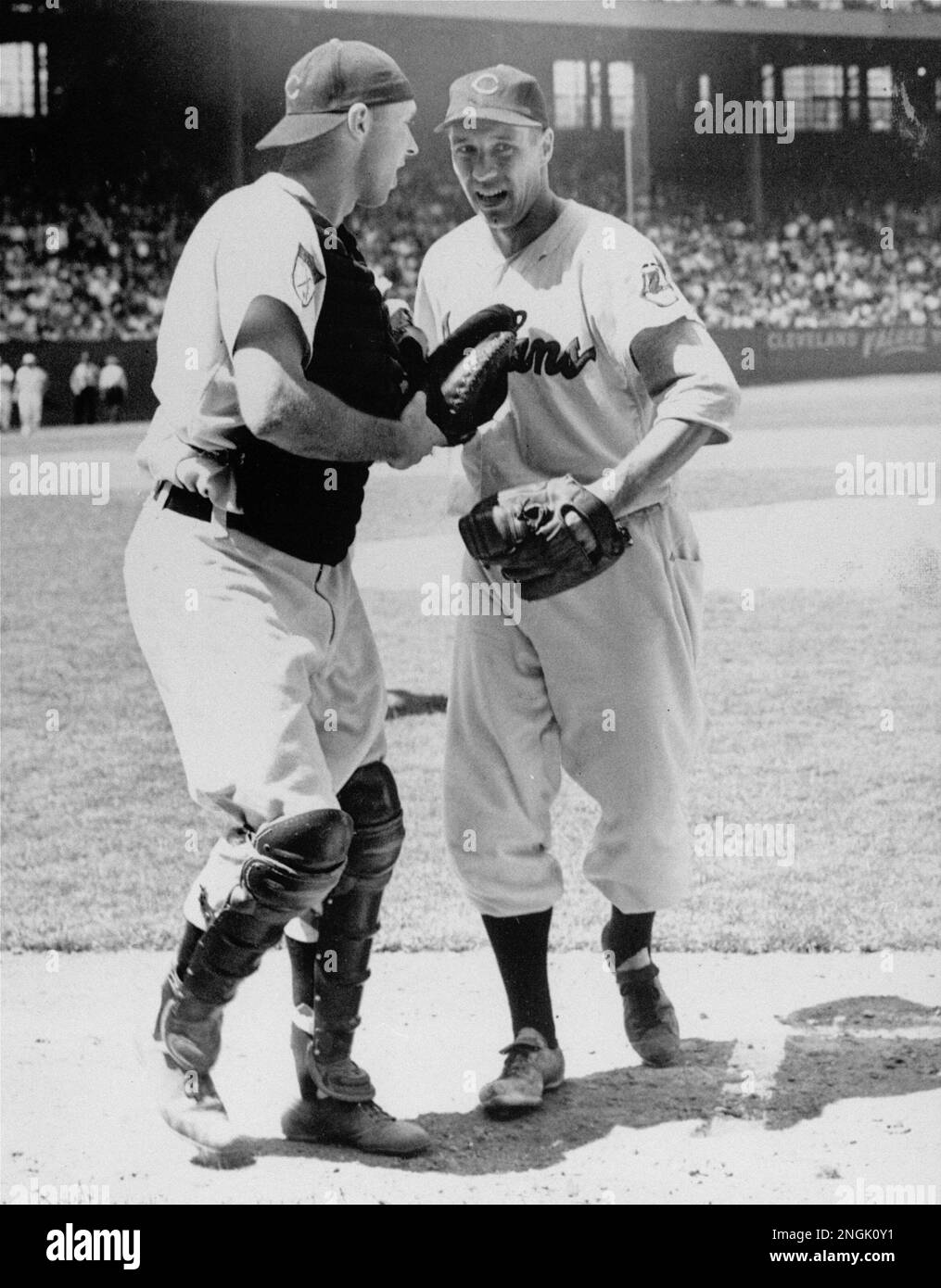 Catcher Jim Hegan of the Cleveland Indians meets Bob Feller on the first base runway to congratulate his battery mate for pitching the third no hitter of his career. Feller walked three and fanned five in beating the Detroit Tigers 2-1 in the opener of double header, July 1, 1951. (AP Photo) Banque D'Images