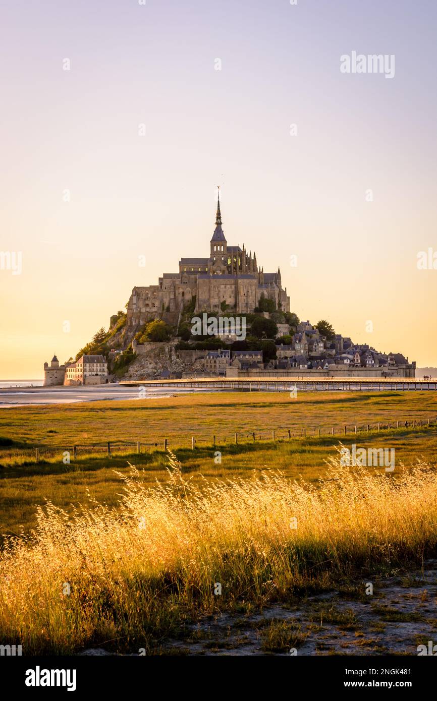 Vue au coucher du soleil sur l'île marémotrice du Mont Saint-Michel en Normandie, France, accessible depuis 2014 par la nouvelle jetée de 800 mètres de long sur pilotis. Banque D'Images