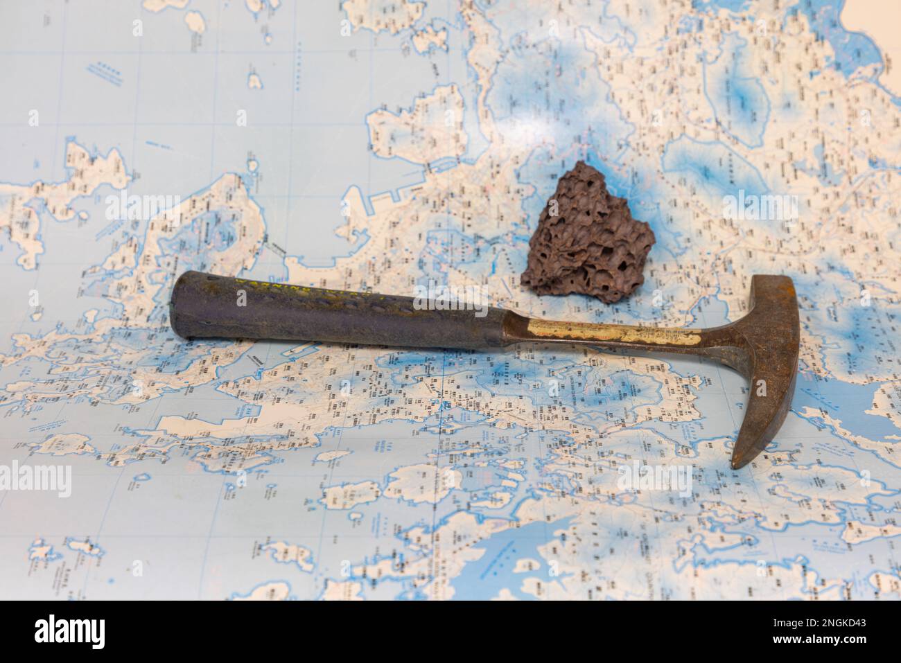 Outils de travail géologique sur le terrain : marteau, boussole, loupe, échantillons de roche, cartes topographiques et géologiques Banque D'Images