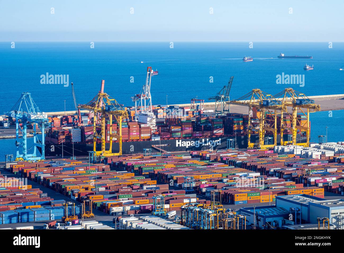 BARCELONE, ESPAGNE - 31 janvier 2023 : le port commercial de Barcelone avec un navire à conteneurs, des grues et des réservoirs de stockage Banque D'Images