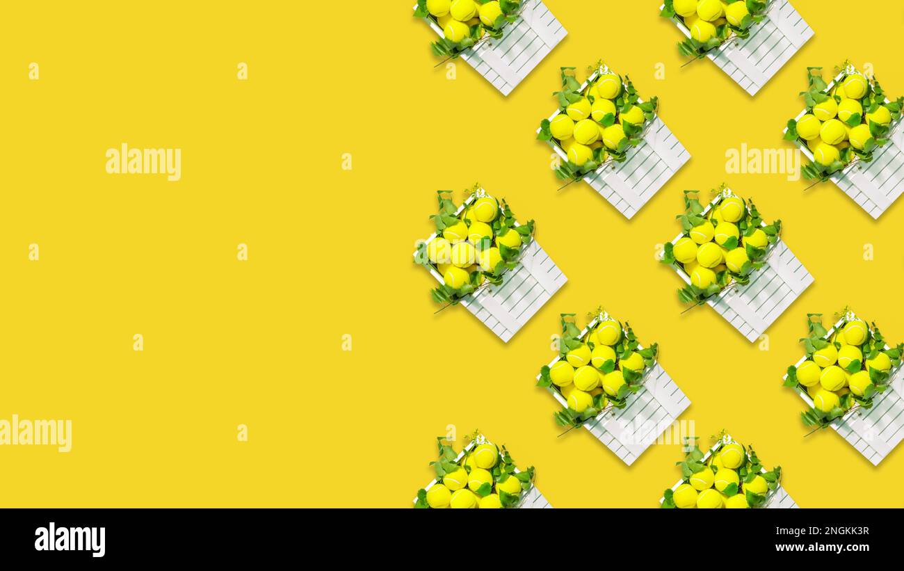 Fond de tennis. Composition sportive avec balles de tennis jaunes dans des boîtes blanches en bois avec des branches vertes sur fond jaune avec espace de copie. Somme Banque D'Images