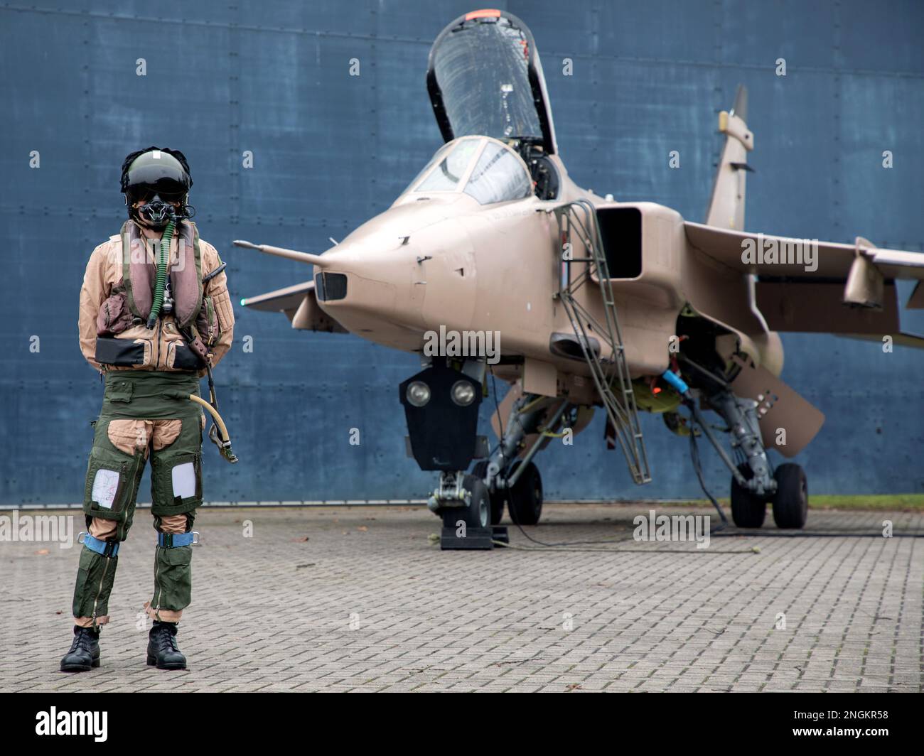 Pilote de chasse, RAF, debout avec Fighter Jet prêt pour une mission de combat portant casque volant, costume et visière sombre avec masque à oxygène Royal Air Force. Banque D'Images