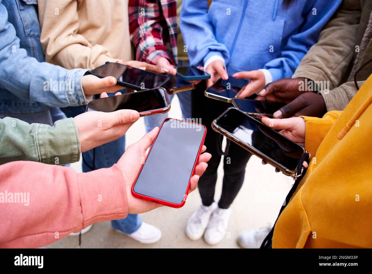 Les personnes qui montrent leur téléphone portable à l'appareil photo avec écran sombre. Concept de toxicomanie et de réseautage social. Banque D'Images