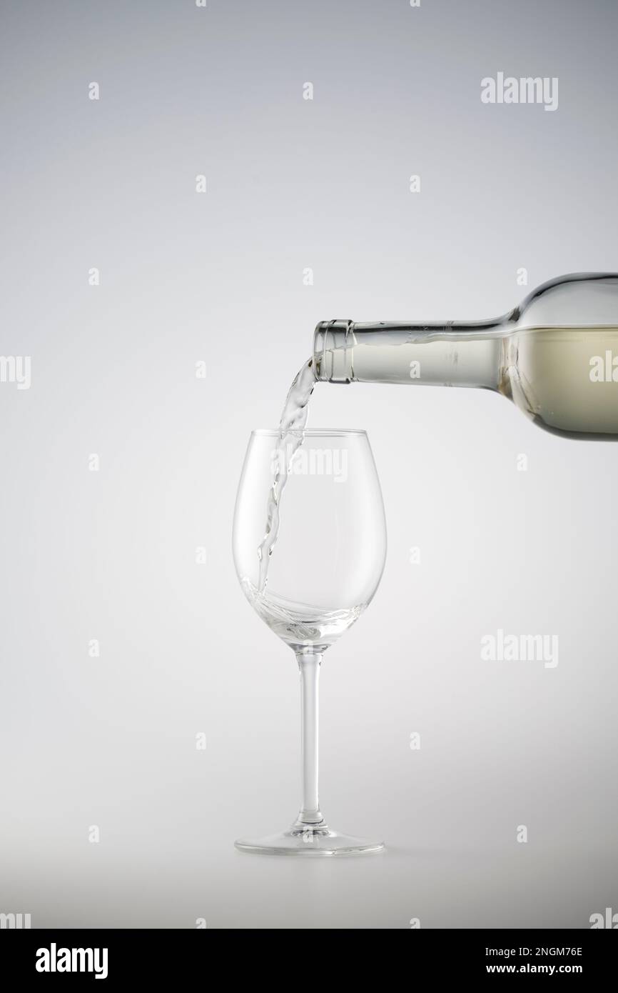 Le vin blanc est versé dans un verre de vin Banque D'Images