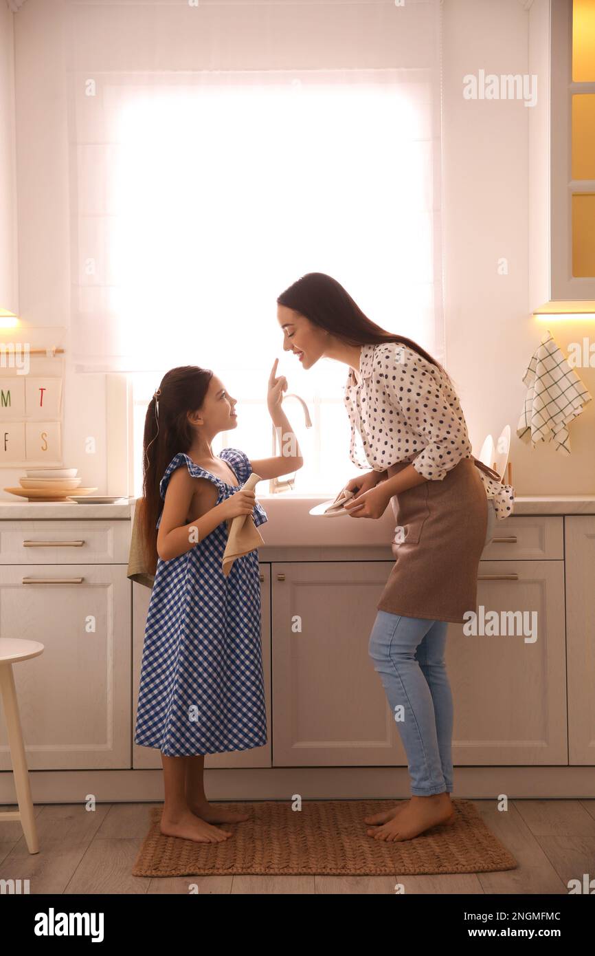 La mère et la fille essuyent les plats ensemble dans la cuisine Banque D'Images