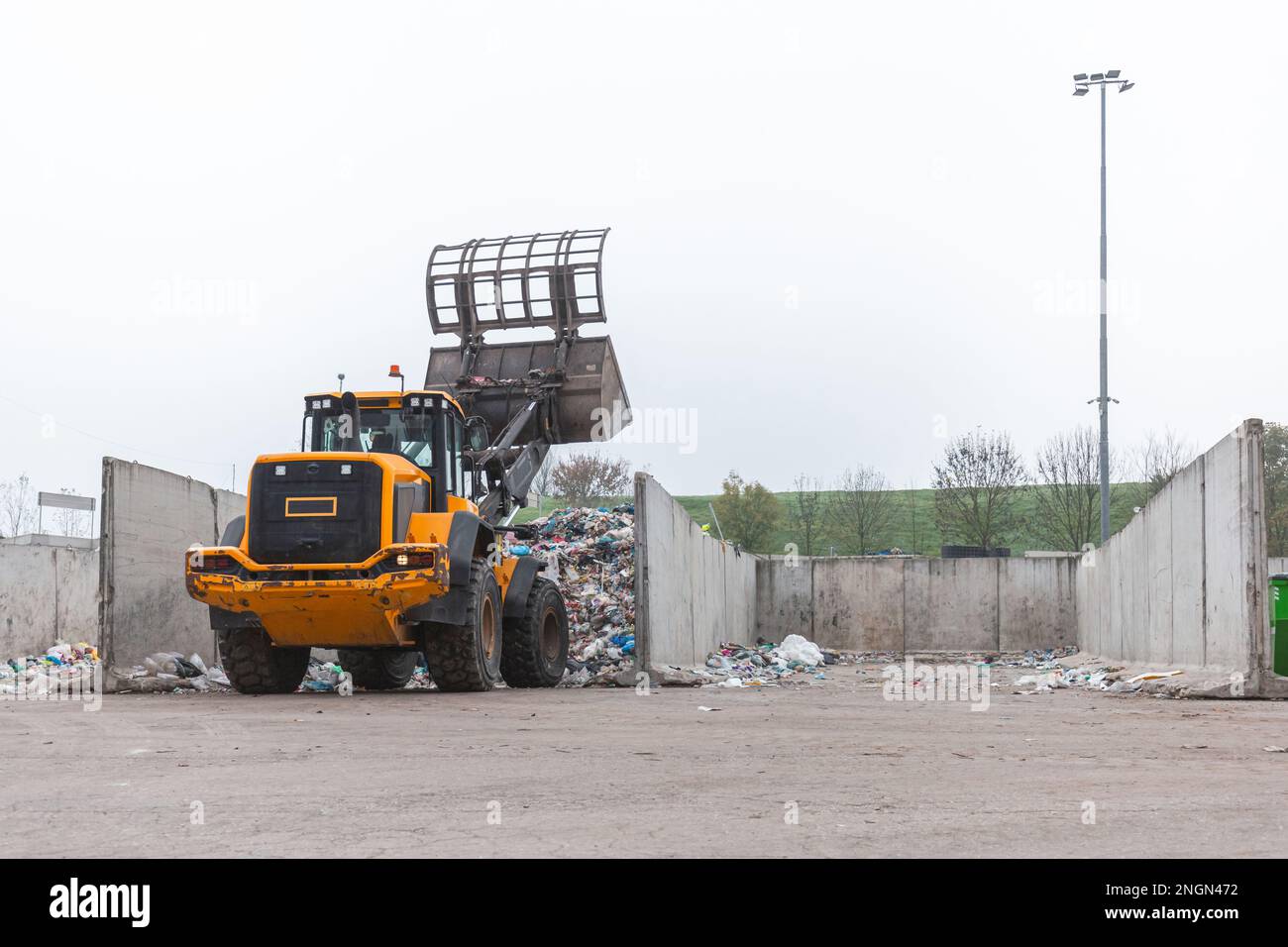 Chargeur frontal avec godet à grappin de traitement des rebuts se déplaçant  vers l'avant et vers l'arrière pour pousser, ramasser et vider les  matériaux dans le centre de recyclage et de traitement