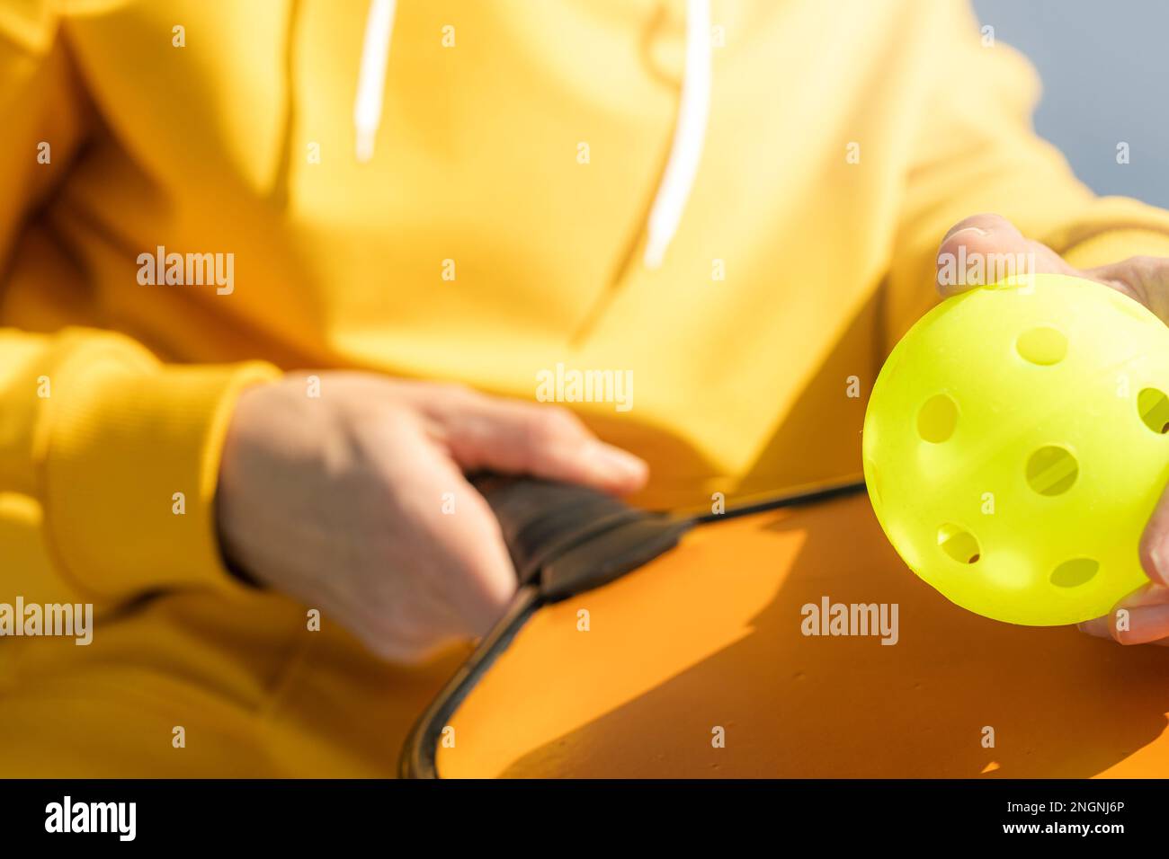 Pickleball paddle et le ballon jaune gros plan, femme jouant au jeu de ...