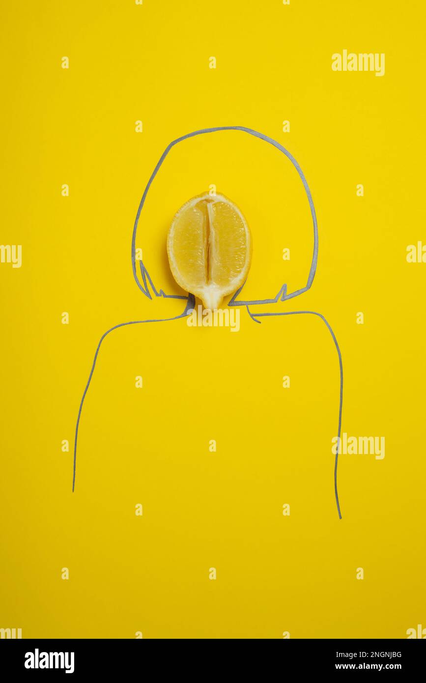 une lime coupée en deux sur un fond jaune uni et la silhouette d'une femme asiatique dessinée, concept de santé féminine, vagin sain, pas de personnes Banque D'Images