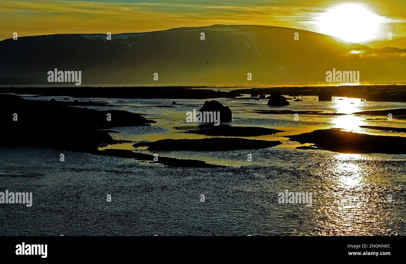 Magnifique lac mystique, coucher de soleil jaune doré, silhouttes de pierres noires et de rochers, reflet des rayons du soleil dans l'eau - lac Myvatn, Iceland High Banque D'Images