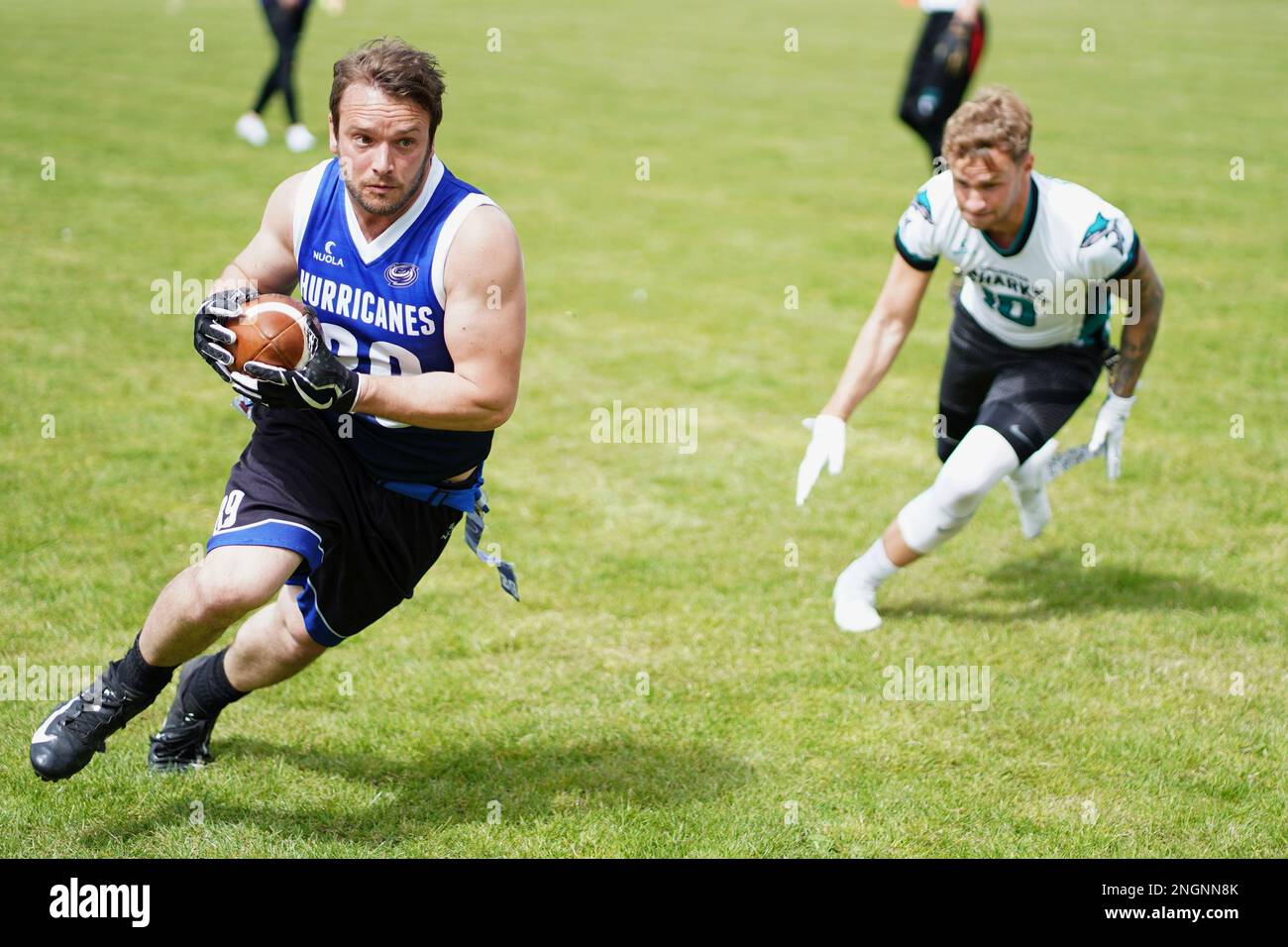 Les joueurs qui jouent avec le ballon lors d'un match de football drapeau au pays de Galles. Banque D'Images