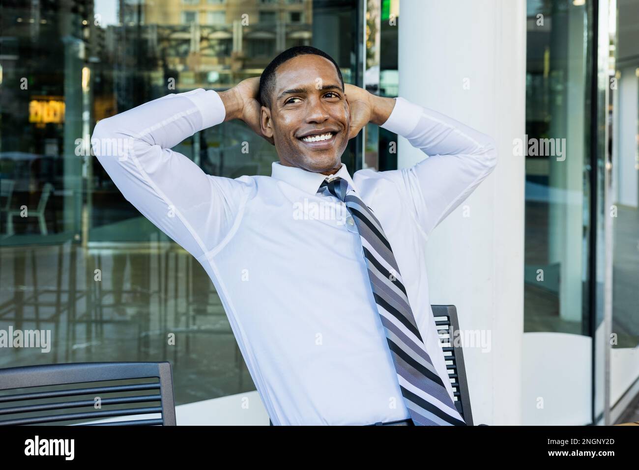 Beau homme d'affaires afro-américain PDG dans un élégant costume d'entreprise dans un centre d'affaires à l'extérieur - Noir homme de banlieue va au travail, Banque D'Images