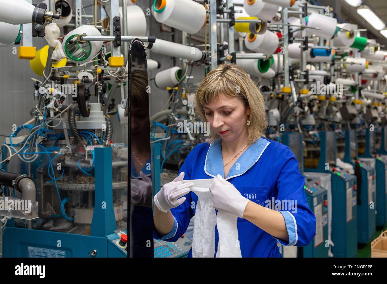 Grodno, Bélarus - 22 novembre 2017: Une employée féminine effectue un contrôle visuel de la qualité de la bonneterie dans JLLC Conte Spa. Même une fabrication de haute précision Banque D'Images