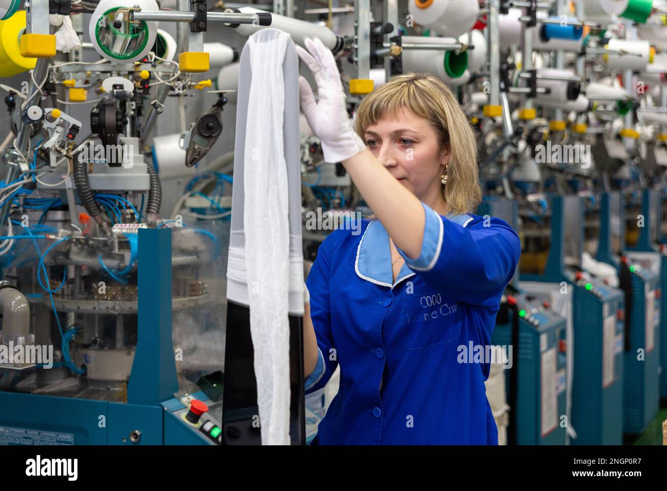 Grodno, Bélarus - 22 novembre 2017: Une employée féminine effectue un contrôle visuel de la qualité de la bonneterie dans JLLC Conte Spa. Même une fabrication de haute précision Banque D'Images
