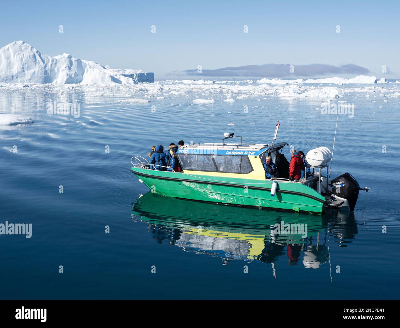 Touristes prenant une excursion sur glace dans un petit bateau observant les icebergs du Ilulissat Icefjord, juste à l'extérieur d'Ilulissat, Groenland. Banque D'Images