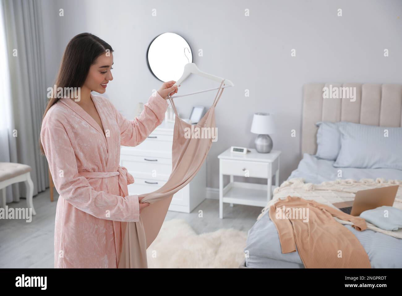 Jeune femme choisissant des vêtements pour le travail à la maison. Routine du matin Banque D'Images