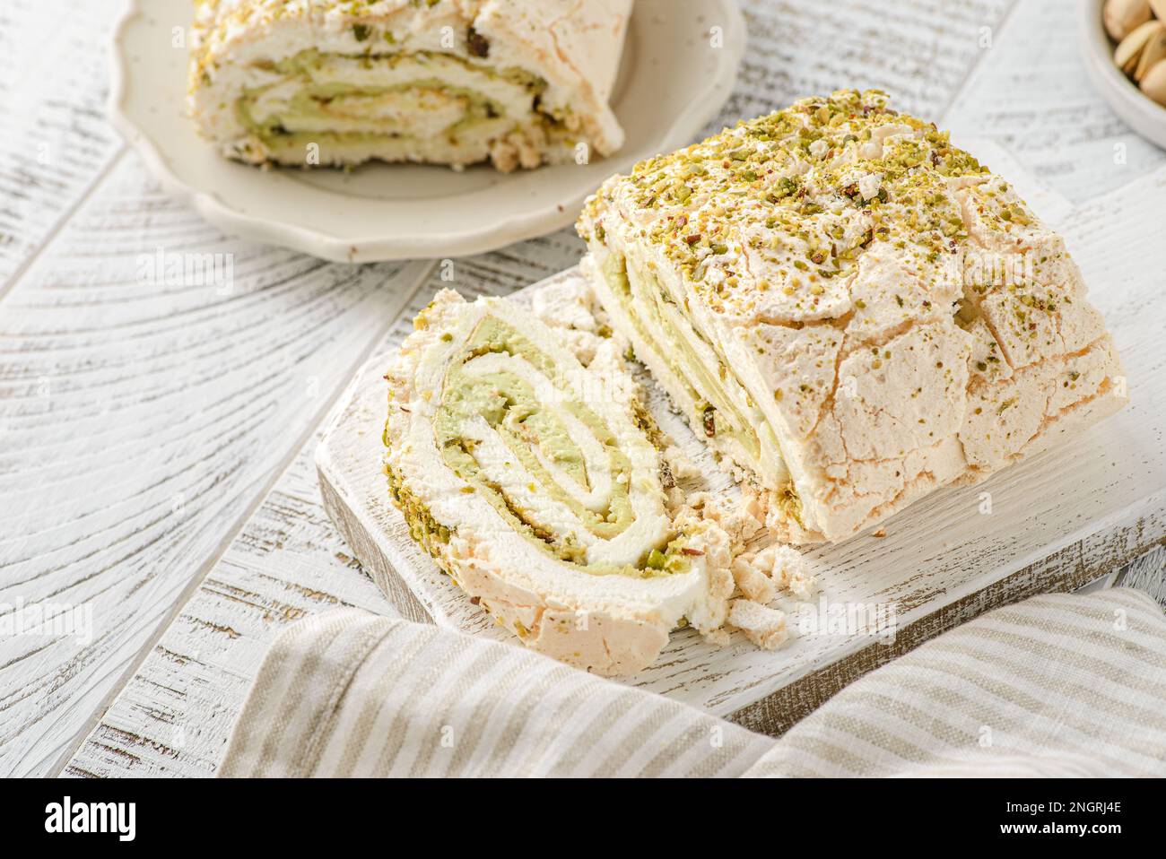 Rouleau de meringue suisse de blancs d'oeufs et de sucre avec pistache, mascarpone. Banque D'Images