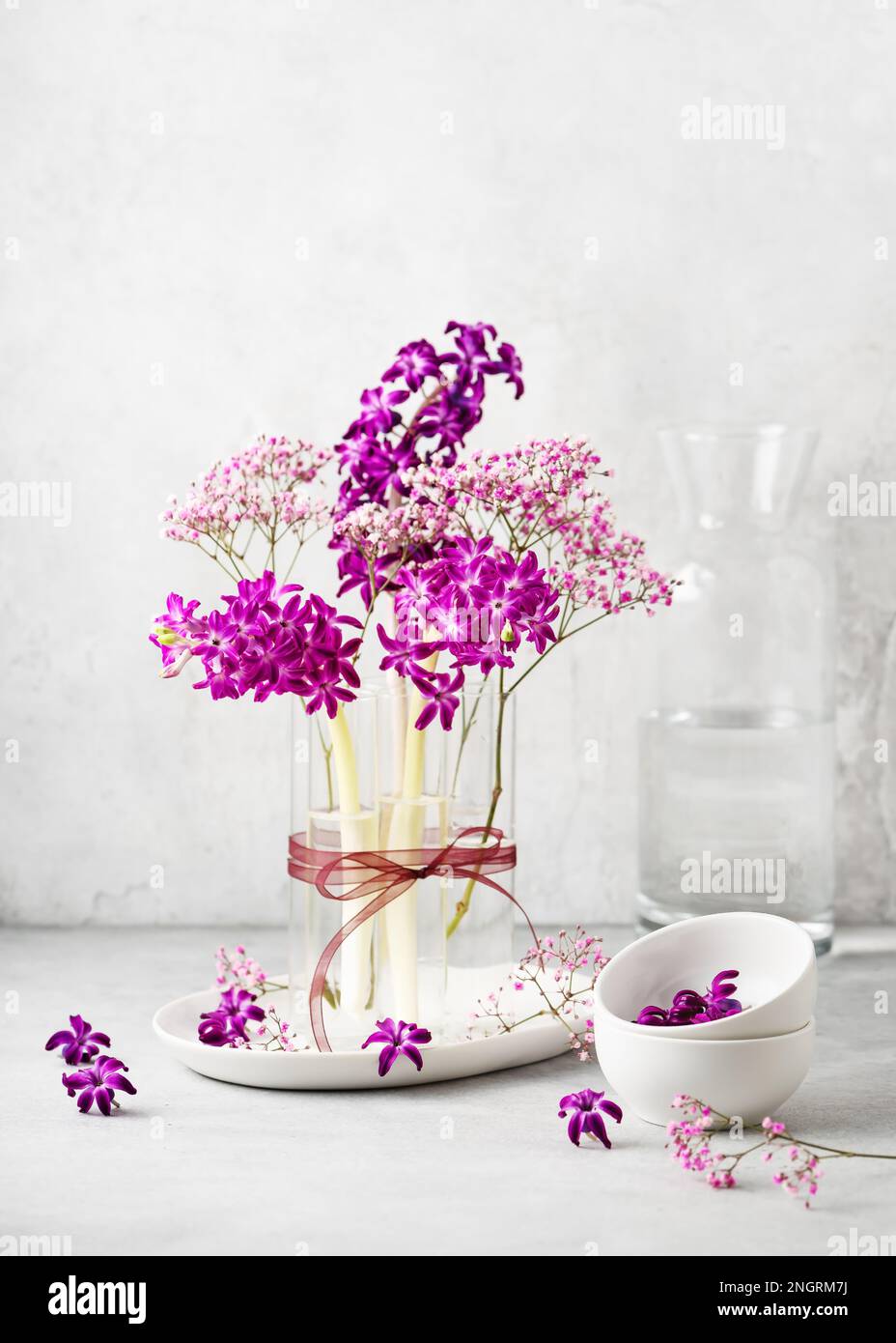 Magnifique arrangement floristique de printemps avec jacinthe pourpre, et fleurs de gitsophila rose dans un vase en verre. Décoration maison pour Pâques, Fête des mères. Banque D'Images