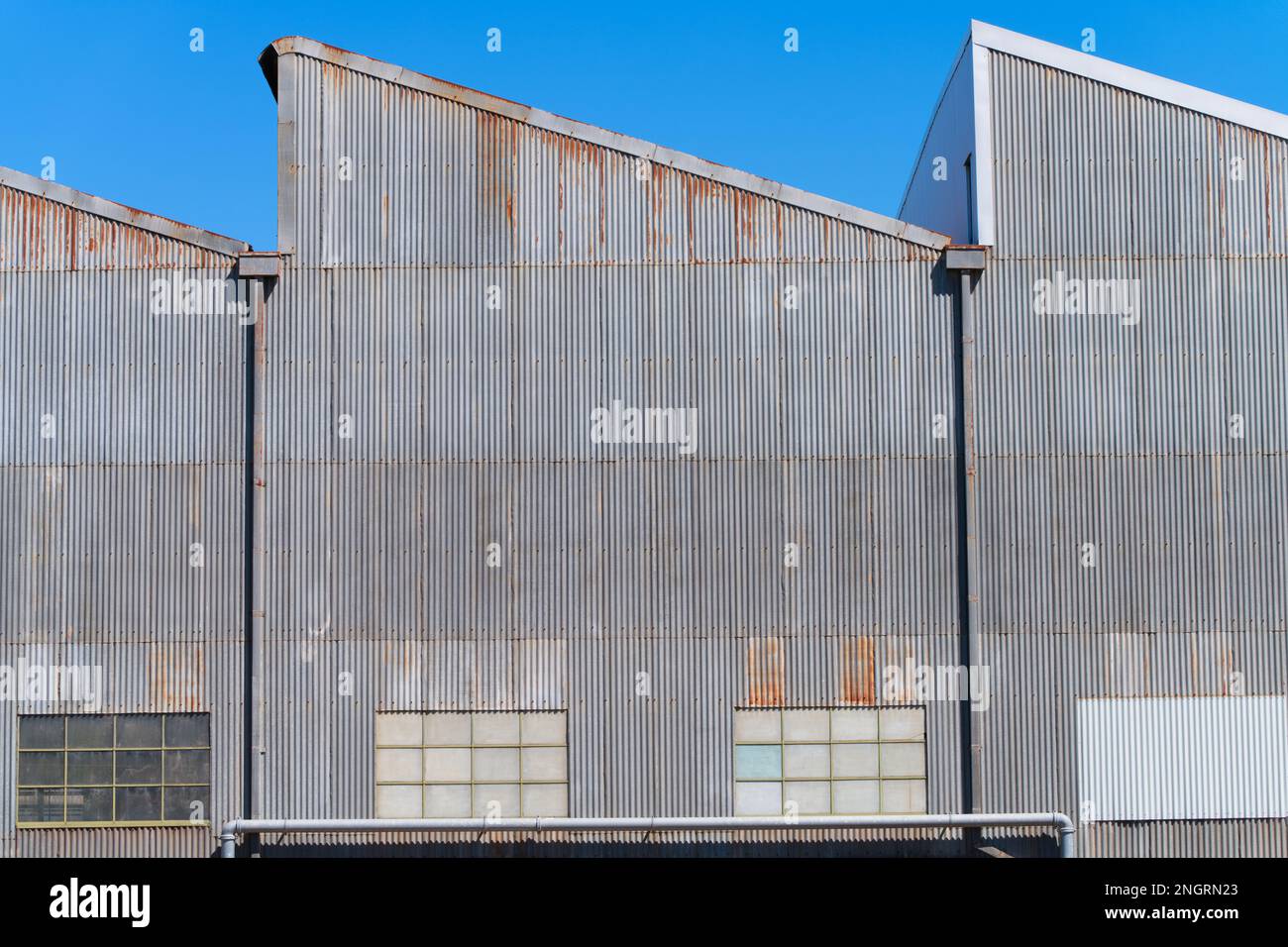 Mur, toit et fenêtres d'une ancienne usine de fonte ondulée en métal avec un ciel bleu sans nuages à Castlemaine en Australie. Banque D'Images
