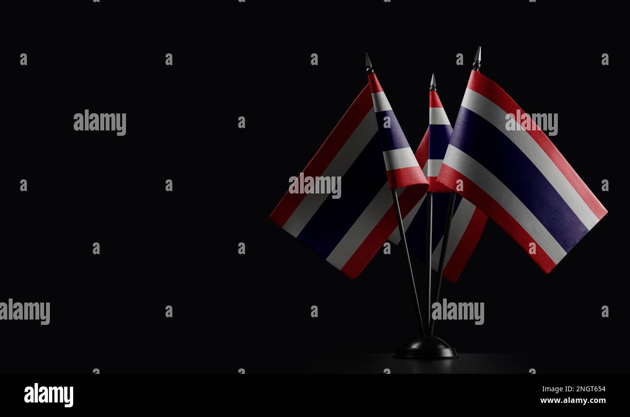 Petits drapeaux nationaux de la Thaïlande sur fond noir. Banque D'Images