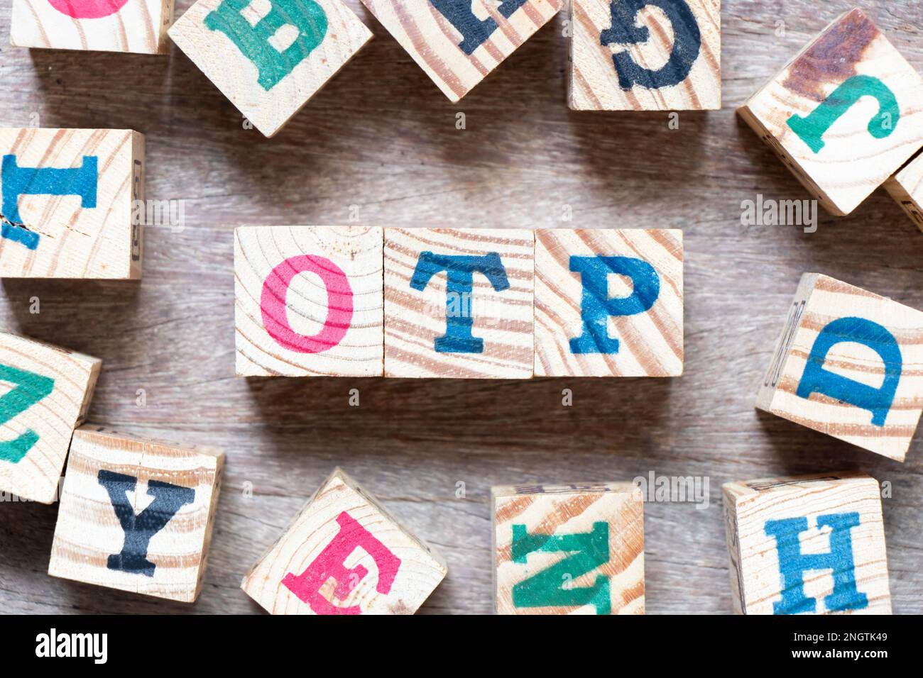 Bloc alphabétique dans le mot OTP (abréviation d'un mot de passe à usage unique) et une autre lettre sur fond de bois Banque D'Images